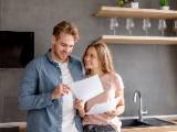 Un homme et une femme regardent un document l'air heureux.