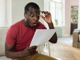 Un homme regarde un document l'air trs tonn.